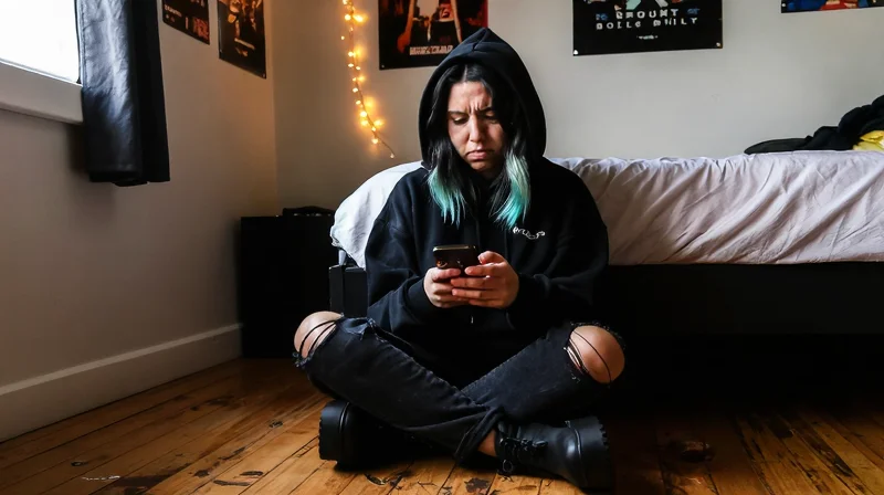 Young alt woman frustrated with AltScene and online dating apps on her phone